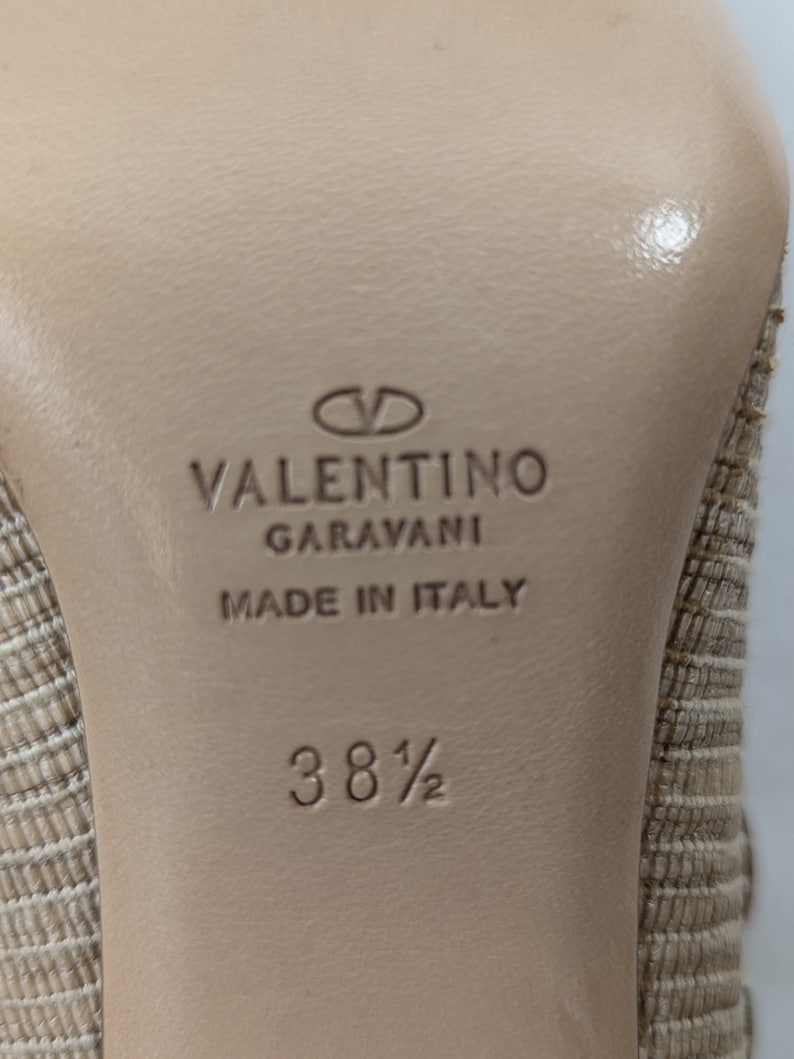 Puede incluir: Primer plano de la suela de un zapato beige con el texto "VALENTINO GARAVANI MADE IN ITALY" y la talla "38 1/2" impresa en &eacute;l.