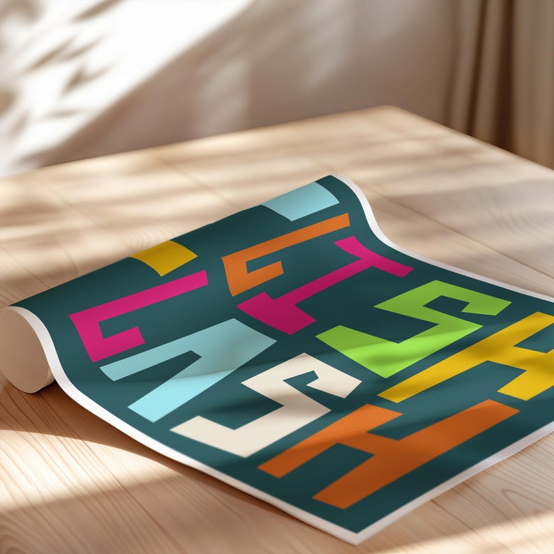 May include: Rolled-up teal poster with the word "ETS" in colorful, bold, block letters. The letters are in various colors, including pink, orange, yellow, and light blue. The poster is on a light wood surface.