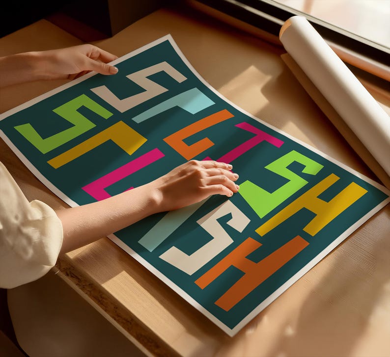 May include: A teal poster with the word "STITCH" in colorful, blocky letters. The letters are in shades of white, yellow, orange, pink, green, and blue. A rolled-up poster is visible in the background.