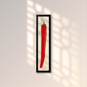 May include: A framed print of a red chili pepper on a white background.