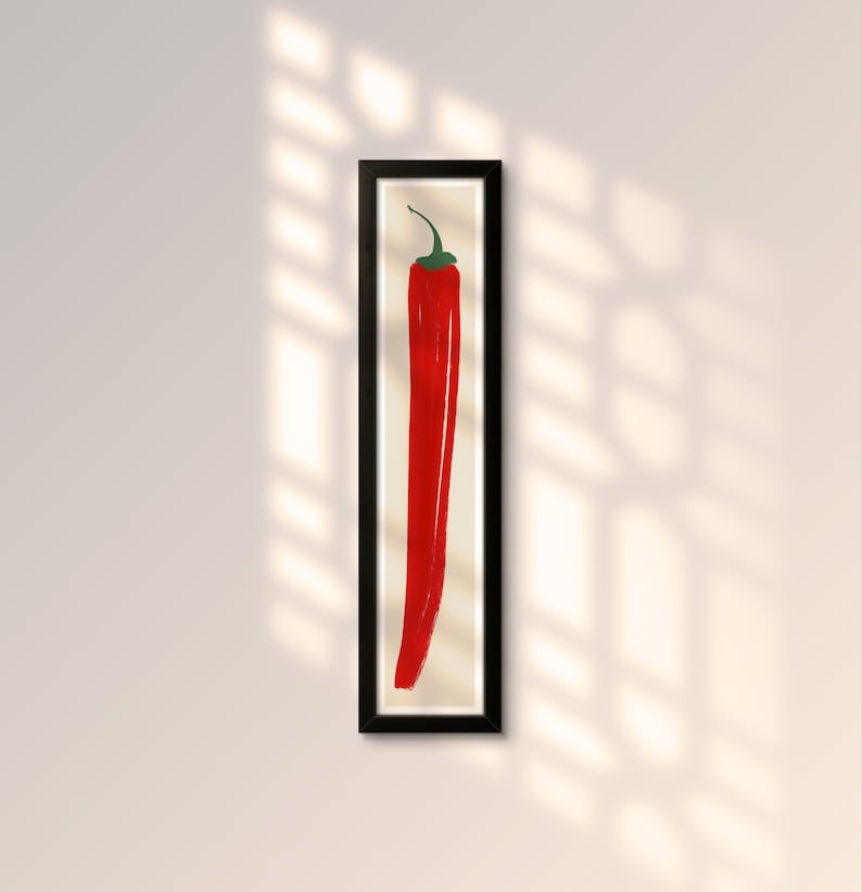 May include: A framed print of a red chili pepper on a white background.
