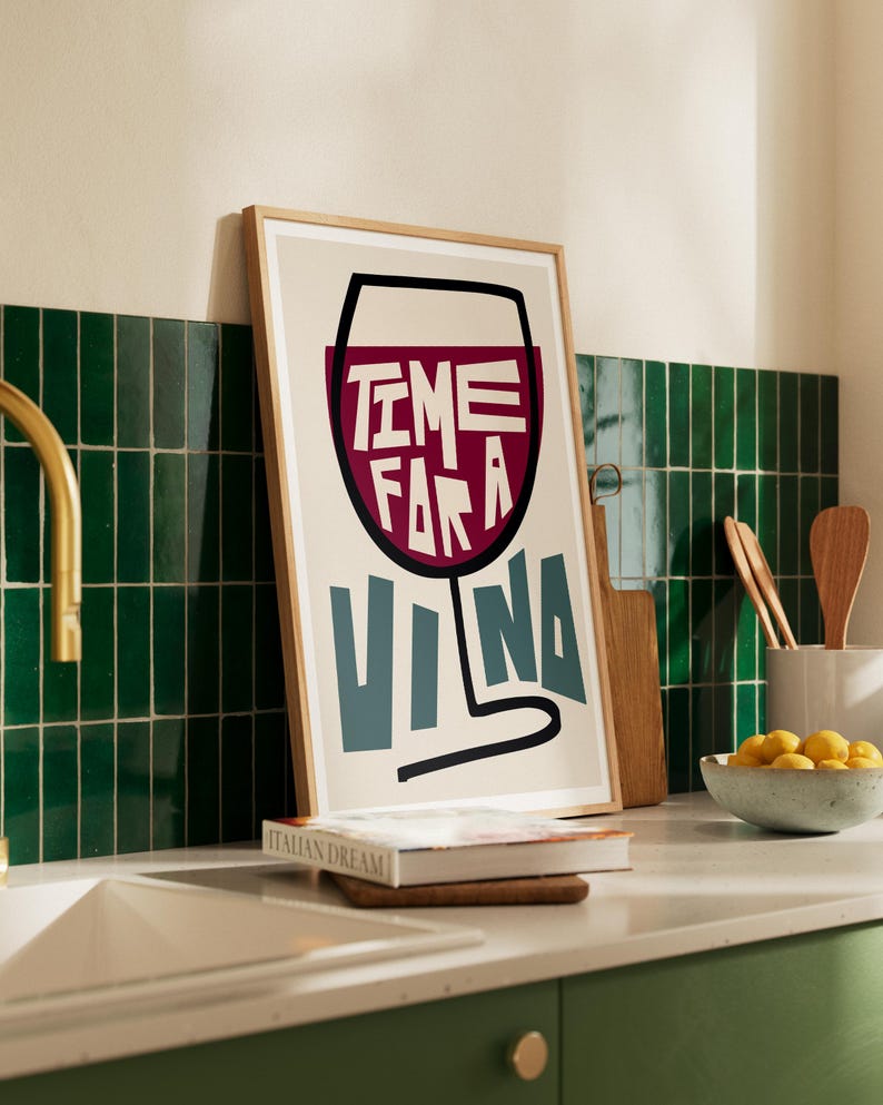 May include: A framed print with a white background and a black outline of a wine glass filled with red wine. The text "TIME FOR A VINA" is written in the glass in a bold, colorful font.