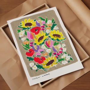 Op de afbeelding: Een bloemenkunstprint met een levendig boeket zonnebloemen, klaprozen en andere bloemen in geel, rood, roze en paars. De print staat tegen een neutrale achtergrond en is ingelijst in een houten kist. De tekst "Flower market" staat onderaan.