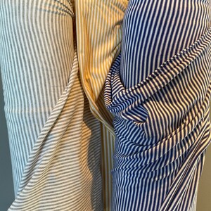 May include: Three rolls of striped fabric. One roll is white and gray, one is yellow and white, and one is navy blue and white.