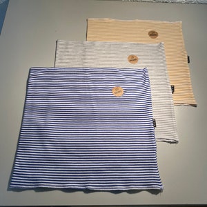 May include: Three striped fabric headbands in blue and white, gray and white, and yellow and white. Each headband has a small brown tag with the word "organic" printed on it.