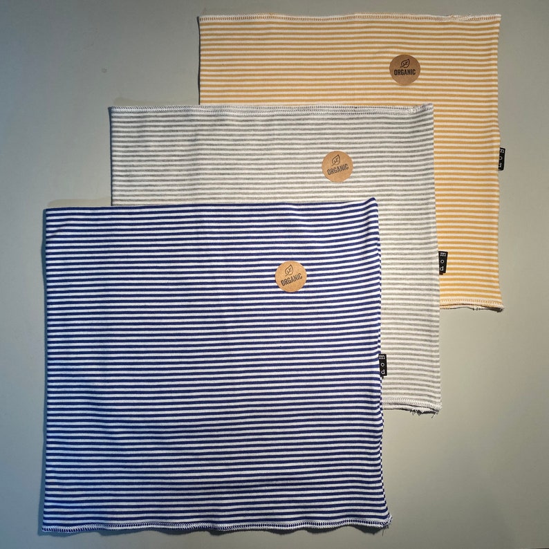 May include: Three striped fabric neck warmers in blue, gray, and yellow with a brown organic label on each.