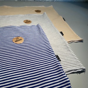 May include: Three striped fabric squares, one blue and white, one gray and white, and one beige and white. Each square has a small brown tag with the word "organic" printed on it.