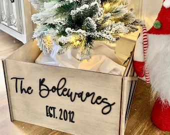 May include: A wooden Christmas tree storage box with a white background and black lettering that reads "The Bolewares EST. 2012".