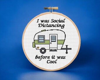 Könnte beinhalten: Ein weißer Stickrahmen mit einem Kreuzstich-Design eines grün-weißen Wohnwagens mit dem Text "I was Social Distancing before it was Cool".