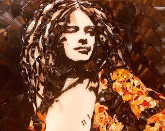 May include: Artwork portrait of a person's face, created from black vinyl records and fragments. The face is a light color, with dark hair and a patterned jacket in shades of orange and gold. The background is made of black vinyl records.