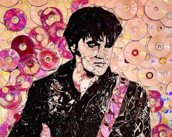May include: An artistic portrait of a person, composed of fragmented images and set against a backdrop of CDs. The person is wearing a black jacket with the word "KING" visible. The artwork features a mix of colors, including black, pink, and beige.