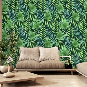 Puede incluir: Un diseño de interior de sala de estar con un sofá marrón y una mesa de café frente a una pared con un papel tapiz de patrón de hojas tropicales. El papel tapiz presenta hojas verdes y azules.