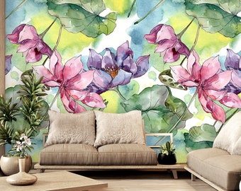 Può includere: Un dipinto ad acquerello di fiori di loto rosa e viola con foglie verdi su uno sfondo bianco. Il dipinto è esposto su una parete in un ambiente di soggiorno con un divano e un tavolino da caffè.