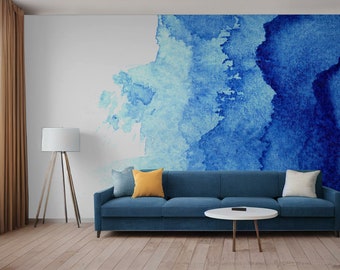 Puede incluir: Un mural de pared de acuarela azul y blanco con un sofá azul y una mesa de café blanca delante.