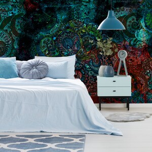 May include: A bedroom with a blue and green patterned wallpaper featuring intricate designs. The bed has a light blue duvet and pillows. A bedside table with a lamp and a clock is next to the bed.