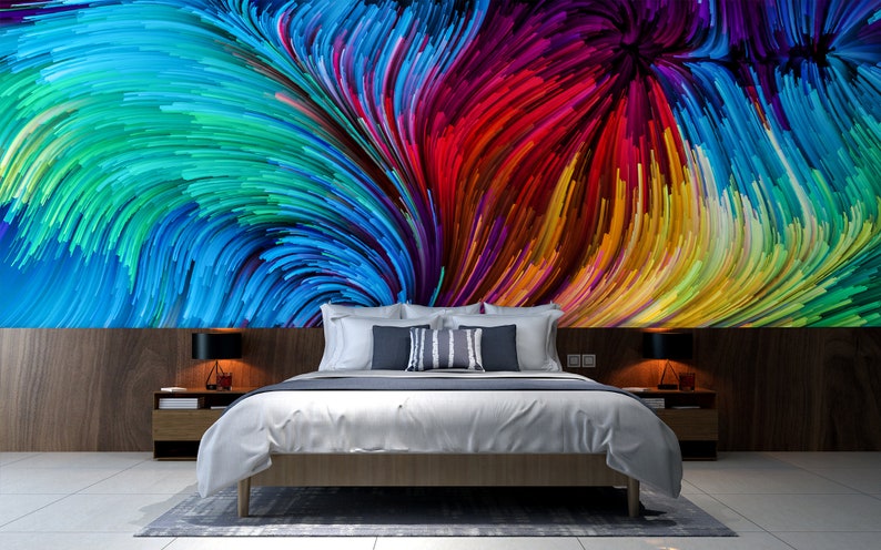 Pu&ograve; includere: Una camera da letto con un letto bianco e una stampa d'arte astratta colorata sul muro. La stampa presenta linee vorticose di blu, verde, rosso, giallo e viola.