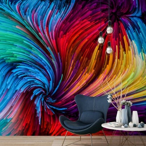 Pu&ograve; includere: Arte murale astratto con un motivo a spirale di linee colorate in tonalit&agrave; di blu, rosso, giallo, verde e viola. L'opera &egrave; esposta in un ambiente da salotto con una sedia e un tavolo.