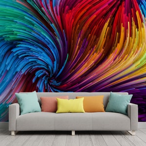 Pu&ograve; includere: Un divano grigio con quattro cuscini colorati davanti a un muro con un dipinto astratto colorato di linee vorticose in tonalit&agrave; di blu, rosso, giallo, verde e viola.