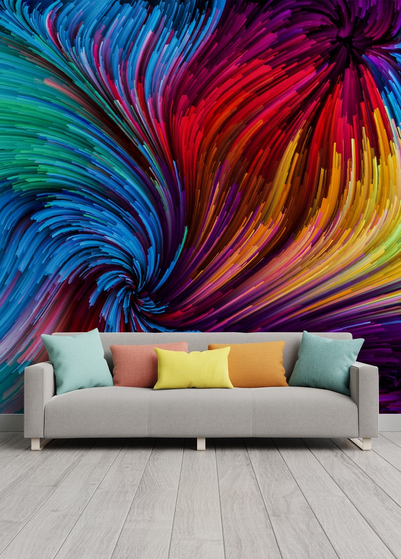 Pu&ograve; includere: Un divano grigio con quattro cuscini colorati davanti a un muro con un dipinto astratto colorato di linee vorticose in tonalit&agrave; di blu, rosso, giallo, verde e viola.