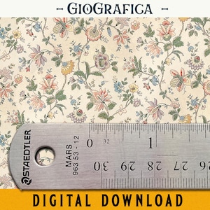 May include: A cream-colored fabric or paper featuring a repeating floral pattern in shades of pink, blue, yellow, and green. A metal Staedtler ruler is placed over the bottom section, showing measurements in inches and centimeters.