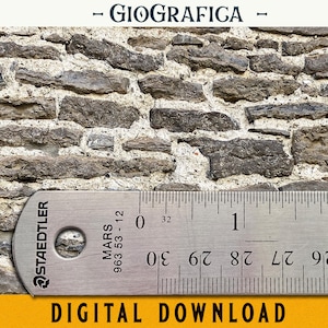 Peut inclure: Gros plan sur un mur en pierre avec une règle mesurant 5 cm. La règle est en argent avec des marques noires et le texte "STAEDTLER MARS 963 53-12" est imprimé sur la règle.