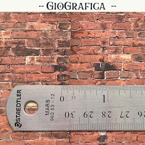 May include: A close-up of a red brick wall with a metal ruler measuring 5 cm. The ruler is labelled "STAEDTLER MARS 963 53-12".