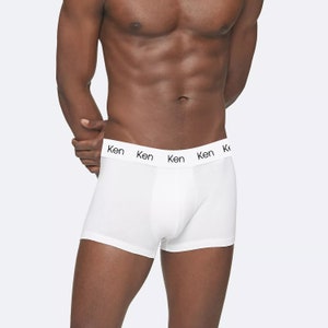 May include: White boxer briefs with a black elastic waistband that says "Ken" four times.