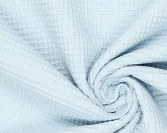 May include: A close-up shot of a light blue waffle-weave fabric. The fabric is soft and textured, with a grid-like pattern. The fabric is draped and swirled, creating a sense of movement and depth. The overall tone is calming and serene.