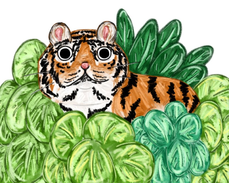 Puede incluir: Un tigre de dibujos animados con rayas naranjas y negras se esconde en una cama de hojas verdes. El tigre tiene ojos grandes y redondos y un hocico blanco.