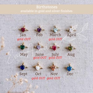 May include: A selection of heart-shaped birthstone pendants with gold wings, each representing a month. Text indicates availability in gold and silver finishes. Some months are marked as "gold OUT".