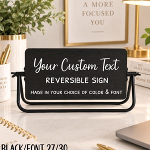 Könnte beinhalten: Ein schwarzes, rechteckiges, beidseitig verwendbares Schild auf einem schwenkbaren schwarzen Metallständer. Das Schild trägt weißen Text: Your Custom Text, REVERSIBLE SIGN, MADE IN YOUR CHOICE OF COLOR & FONT. Das Schild steht horizontal auf einer Fläche.