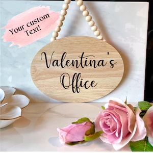 Pu&ograve; includere: Un cartello ovale in legno con il testo "Valentina's Office" in lettere corsive nere. Il cartello &egrave; appeso a una corda di perline di legno.