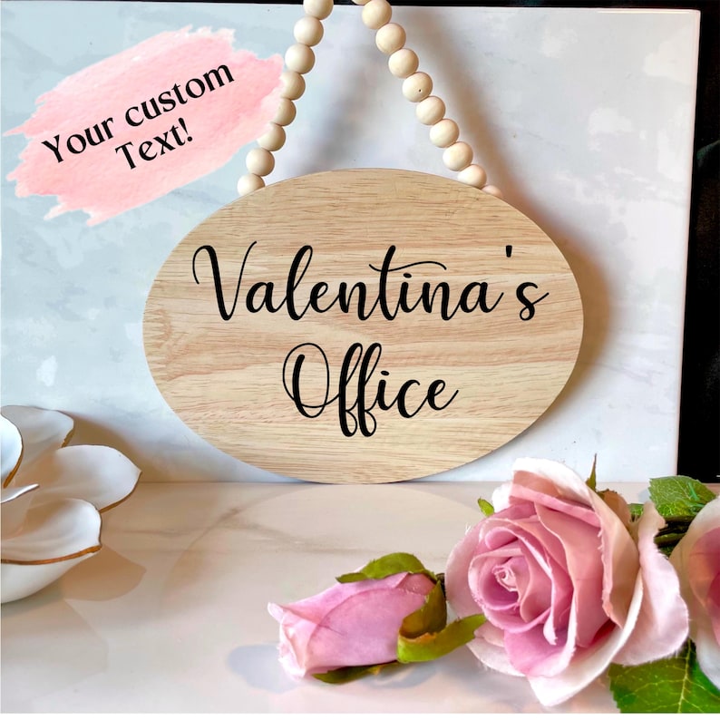 Pu&ograve; includere: Un cartello ovale in legno con il testo "Valentina's Office" in lettere corsive nere. Il cartello &egrave; appeso a una corda di perline di legno.