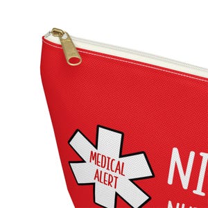 May include: Red zippered pouch with a white medical alert symbol and the text "MEDICAL ALERT" inside the symbol. The text "NICE TO MEET YOU, I HAVE A MEDICAL ALERT" is printed below the symbol.