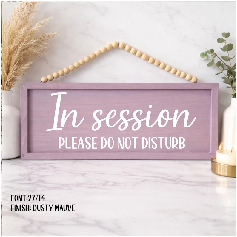 Peut inclure: Panneau en bois mauve poussi&eacute;reux avec le texte blanc "In session PLEASE DO NOT DISTURB". Le panneau rectangulaire est suspendu par un cordon de perles en bois. C'est un objet d&eacute;coratif.