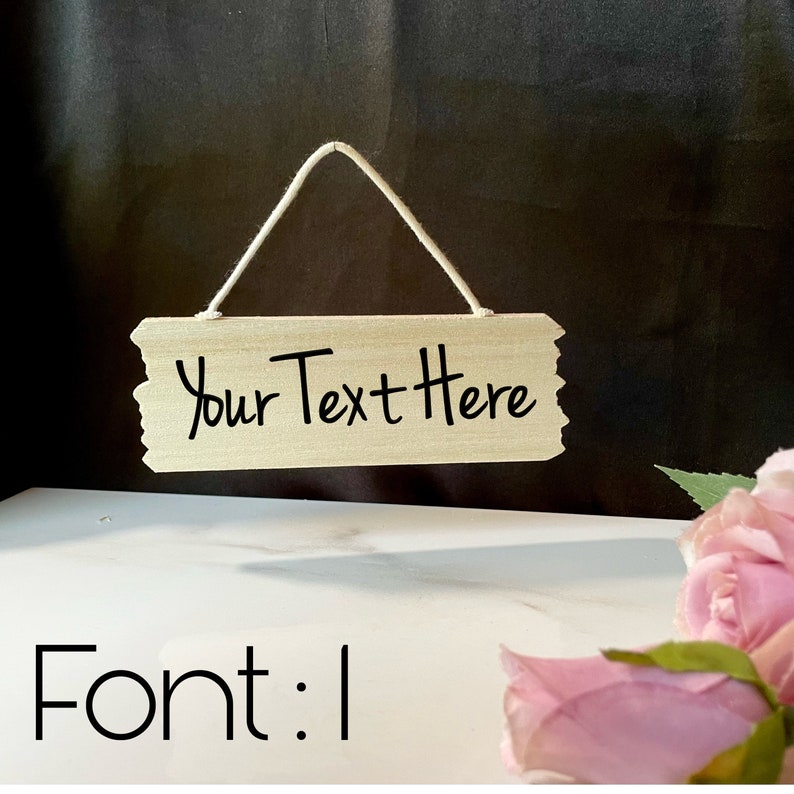 May include: A wooden sign with a string for hanging. The sign has the text "Your Text Here" written in black cursive font.