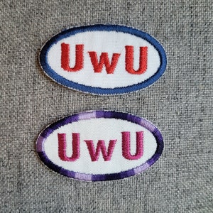 May include: Two white oval patches with the text "UwU" embroidered in red and pink thread. The patches have blue and purple stitching around the edges.