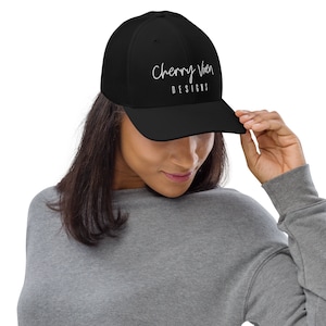 May include: Black mesh trucker hat with a white embroidered logo that says "Cherry Wren Designs".