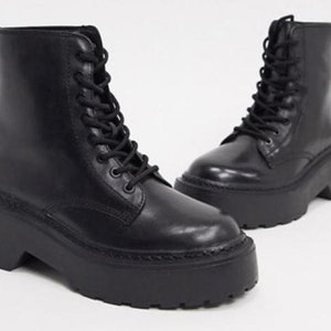 May include: Black leather lace-up platform boots with a chunky heel.
