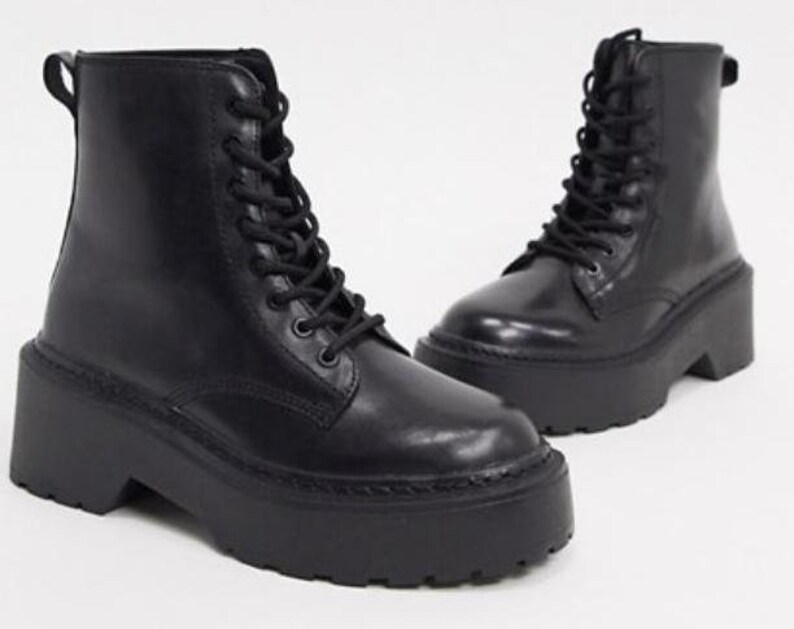May include: Black leather lace-up platform boots with a chunky heel.