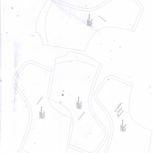 May include: Four white paper patterns for sewing a garment. The patterns are labeled with measurements in inches.