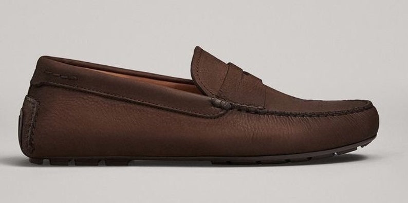 Peut inclure: Mocassins de conduite en cuir marron avec un d&eacute;tail de bride penny.