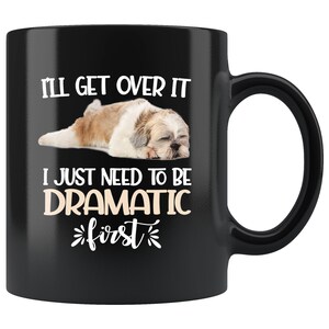 May include: Black coffee mug with a white graphic of a Shih Tzu dog sleeping. The text on the mug reads "I'll get over it I just need to be dramatic first."
