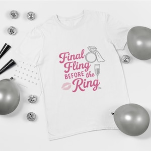 May include: White t-shirt with the text "Final Fling Before the Ring" in pink script, along with a diamond ring, champagne flute, and a kiss graphic. The shirt is surrounded by silver balloons and disco balls.