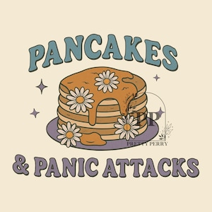 Può includere: Un design grafico con il testo "Pancakes & Panic Attacks" in testo viola. Un mucchio di pancake con sciroppo e fiori è al centro del design.
