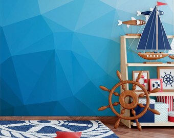 Puede incluir: Una alfombra azul y blanca con temática náutica con una almohada roja en forma de estrella en el centro. Un timón de barco de madera está en el suelo junto a una estantería de madera con decoraciones náuticas.