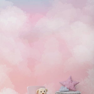 May include: A pink children's chair with a teddy bear sitting on it. A white wicker basket with a pink star-shaped pillow on top sits next to the chair. The background is a pink and blue watercolor-style wall with clouds.