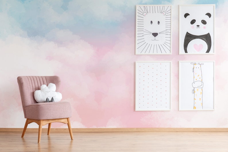 May include: A pink armchair with a white cloud-shaped pillow sits in front of a wall with a pink and blue watercolor cloud design. Four framed illustrations of animals hang on the wall: a lion, a panda, a giraffe, and a pattern of dots.