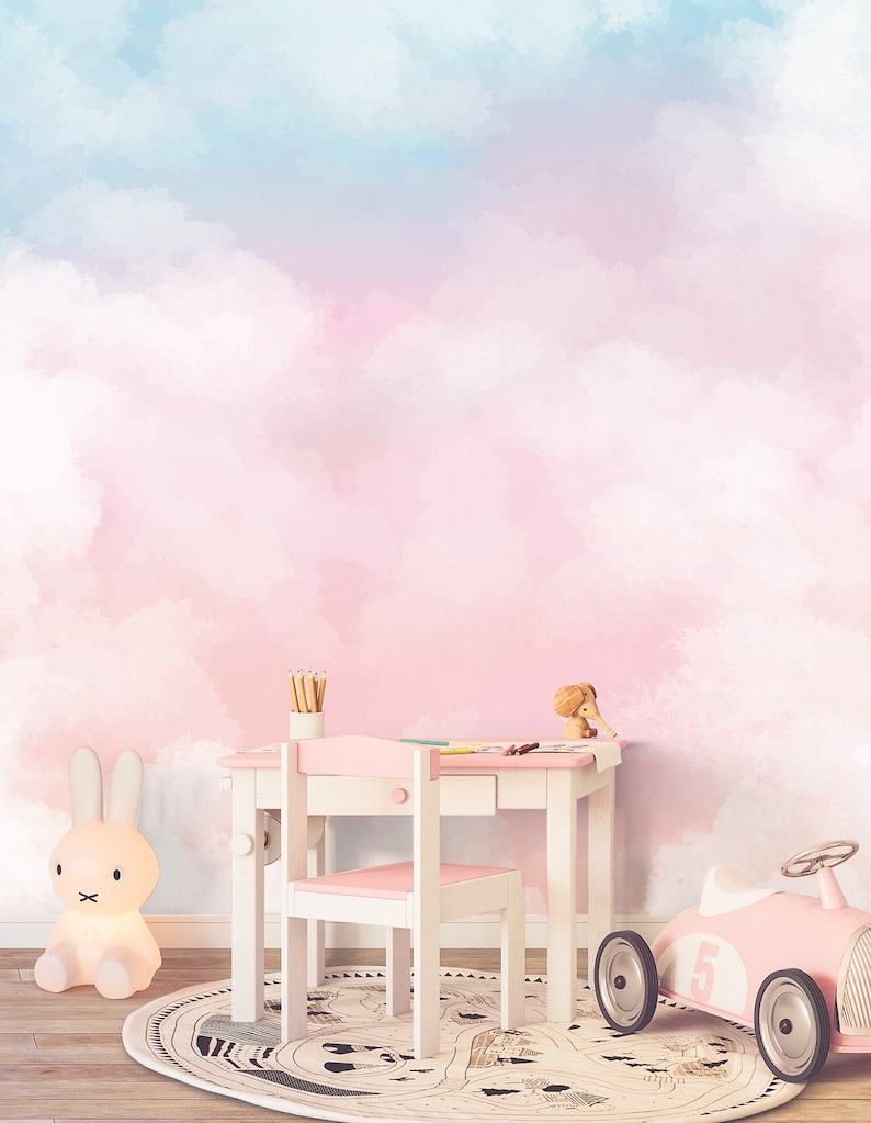 May include: A pink and blue watercolor cloud wall mural with a white desk and chair, a pink toy car, and a white bunny nightlight.