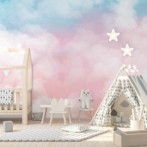 May include: A pink and blue watercolor cloud nursery wall mural with a white crib, a white teepee tent, a white bunny chair, and a white stuffed animal.
